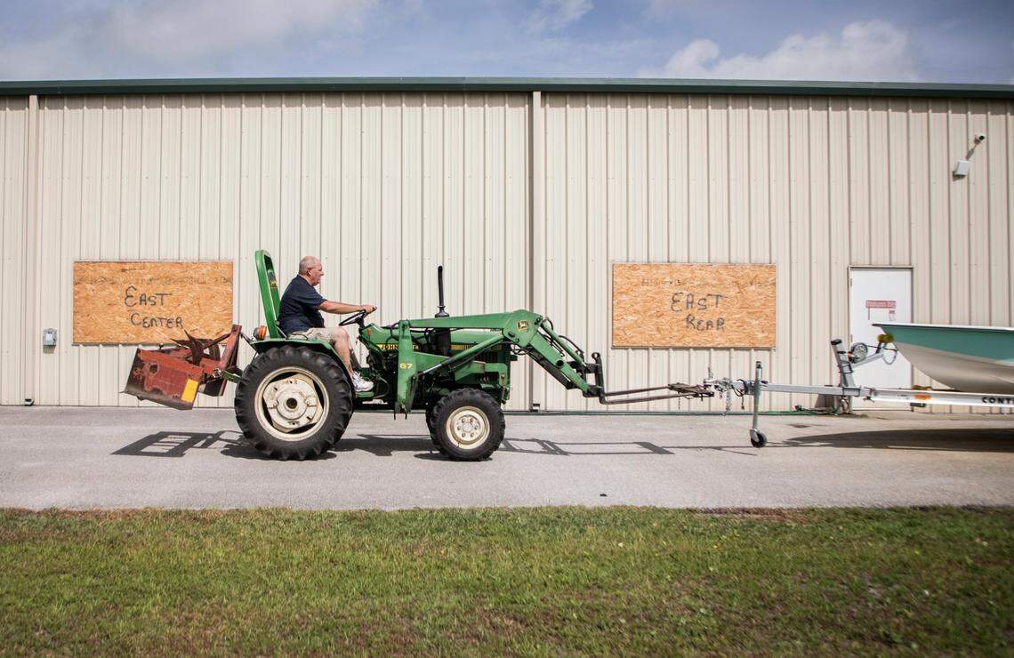 Lee Nelson moves a boat to the back entrance of Downeast Marine Otway, N.C. to be stored in a garage in preparation for the arrival of Hurricane Isaias on Monday, Aug. 3, 2020.