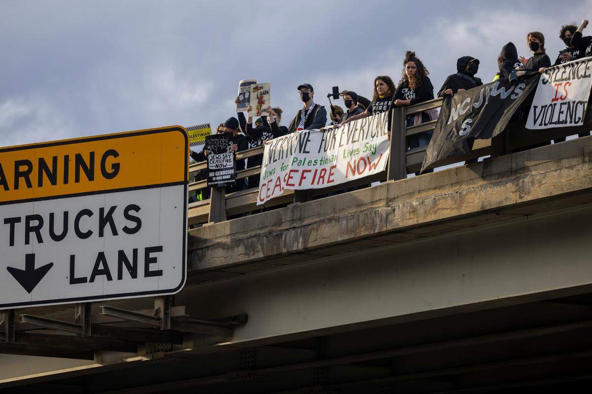 A group of demonstrators organized by Jewish Voice for Peace hold signs and banners on both sides of the North Harrison Avenue overpass over Interstate 40 in Cary Wednesday afternoon, Nov. 22, 2023. The demonstrators were calling for a cease-fire in Gaza.