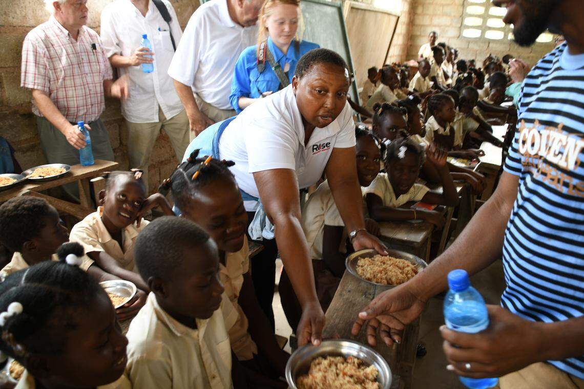 Edna Ogwangi of Raleigh-based Rise Against Hunger serves lunch to the children of Phillipe Gurrier School in the Gonaives area. The school serves meals from Rise Against Hunger four days a week.