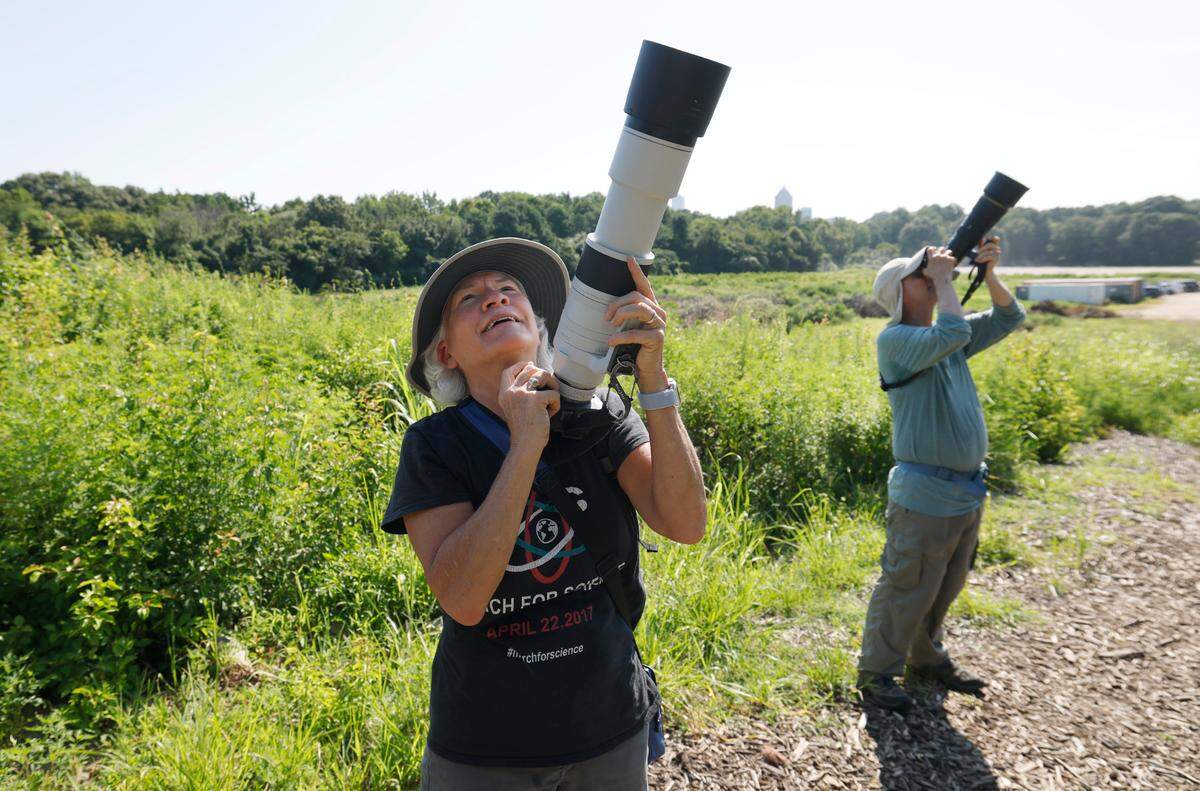 Lori White, left, and Scott Ellis look for a painted bunting and other birds while at Dix Park in Raleigh, N.C., Thursday morning, July 24, 2025.