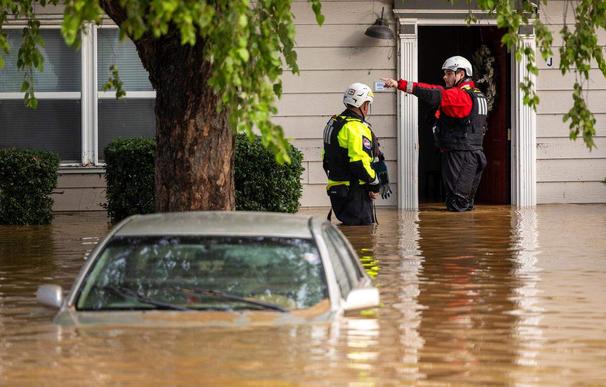 A water rescue unit with the Durham Fire Department knocks on doors at Rippling Streams Townhomes in the Old Farm neighborhood along the Eno River in Durham on Monday morning, July 7, 2025, after flash flooding caused by Tropical Storm Chantal.