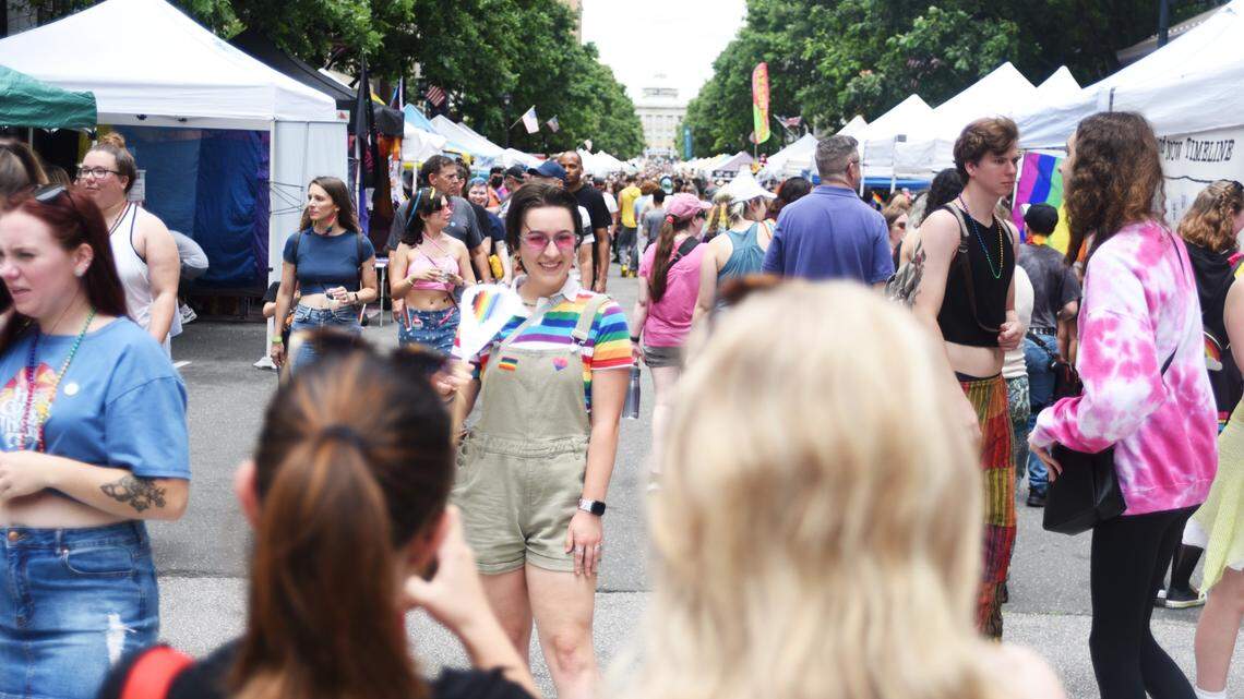 During Out Raleigh Pride, Lauren Kane poses for a photo under a rainbow arch in the middle of Fayetteville Street.