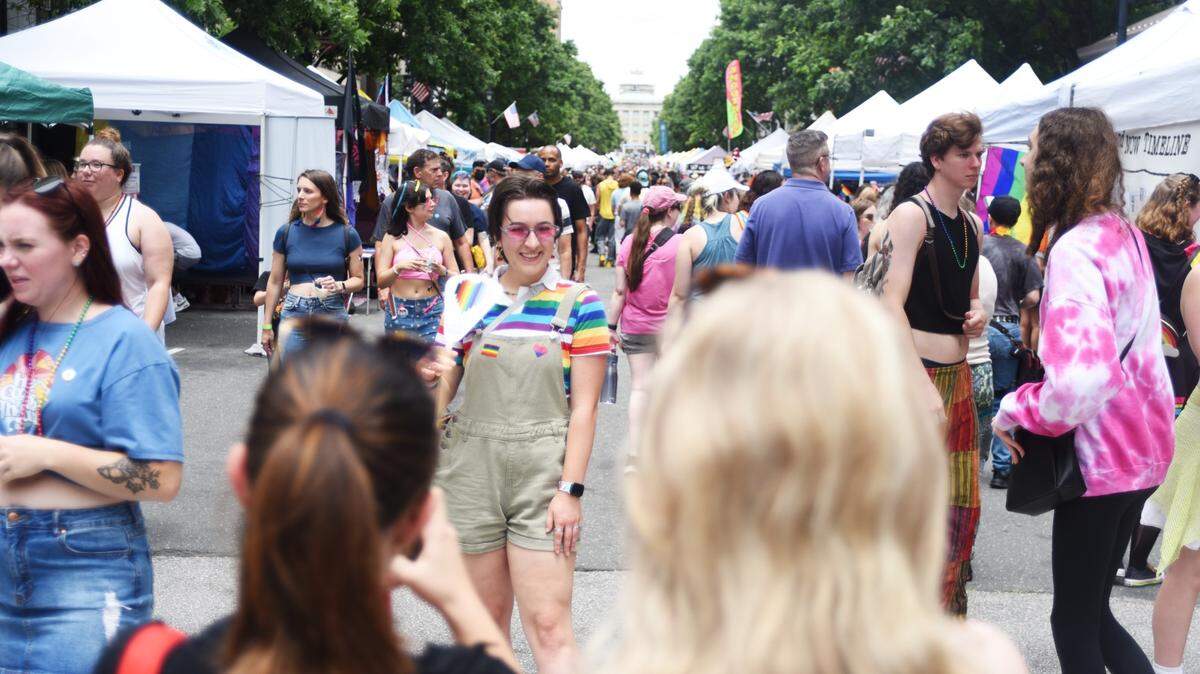 During Out Raleigh Pride, Lauren Kane poses for a photo under a rainbow arch in the middle of Fayetteville Street.