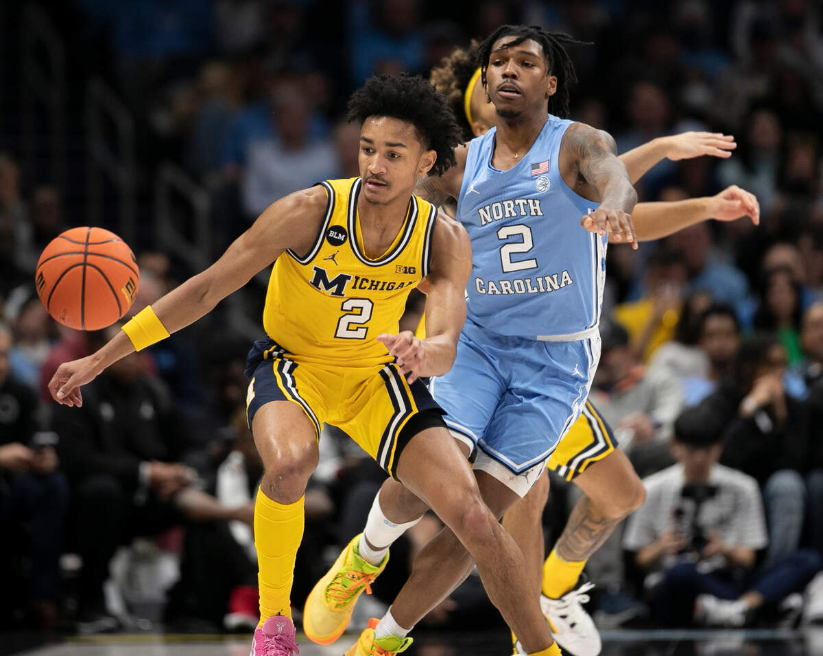 North Carolina’s Caleb Love (2) forces a turnover by Michigan’s Kobe Bufkin (2) in the first half against Michigan on Wednesday, December 21, 2022 at the Spectrum Center in Charlotte, N.C.