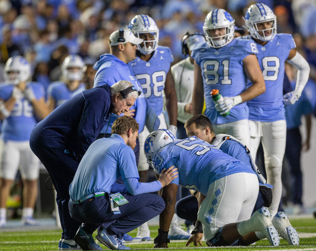 North Carolina coach Mack Brown checks on injured offensive lineman Willie Lampkin (53) during the first half against Virginia on Saturday, October 21, 2023 at Kenan Stadium in Chapel Hill, N.C.