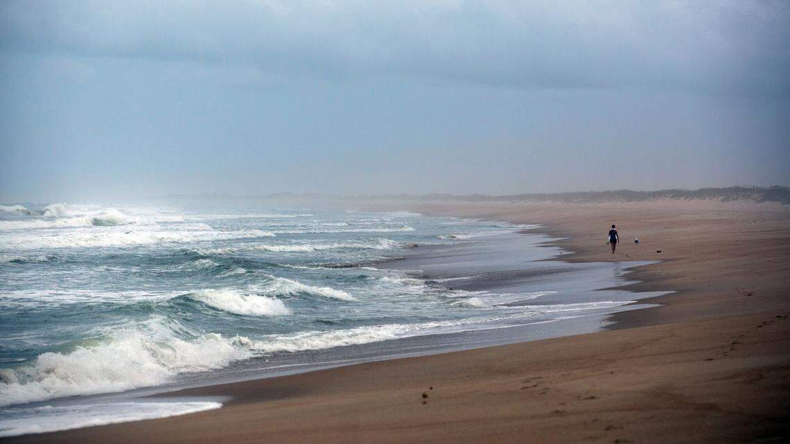 A woman walks along the Cape Hatteras National Seashore Wednesday evening, Sept. 4, 2019.