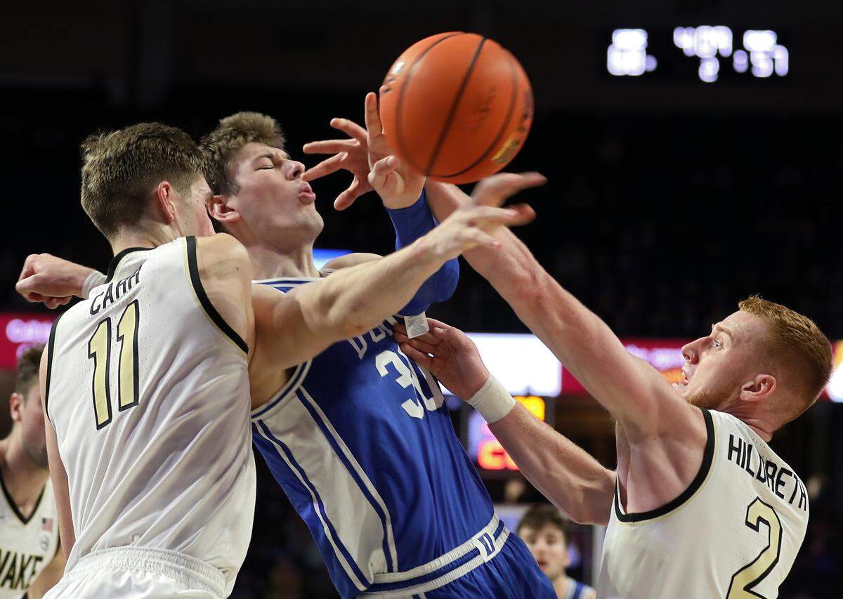 Duke’s Kyle Filipowski is pressured by Wake Forest’s Andrew Carr and Cameron Hildreth during the second half of a men’s basketball game on Tuesday, Dec. 20, 2022, at Lawrence Joel Veterans Memorial Coliseum in Winston-Salem, N.C.