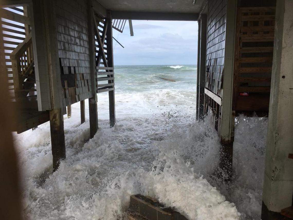 Waves crash into the support beams of a Rodanthe house that is slowly crumbling into the ocean.