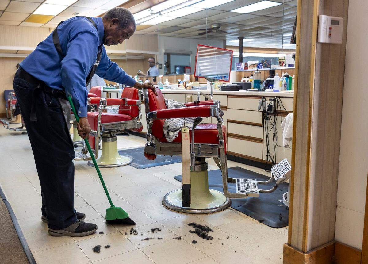 Sylvester White sweeps the floor at White’s Barber Shop on Thursday, May 15, 2025, in Raleigh, N.C. White has operated his shop since 1967.