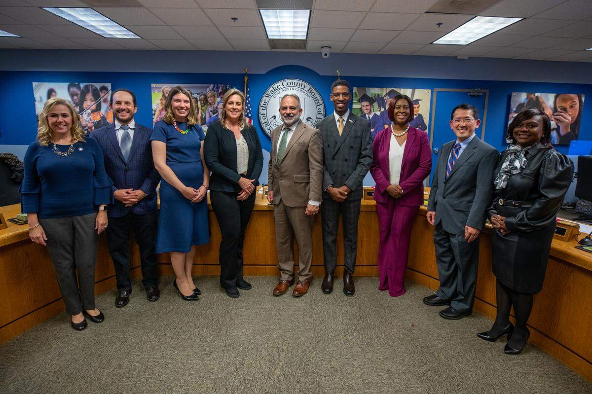 Wake County school board members Lynn Edmonds, Sam Hershey, Lindsay Mahaffey, Cheryl Caulfield, Chris Heagarty, Tyler Swanson, Tara Waters, Dr. Wing Ng and Monika Johnson-Hostler take a group photo after being sworn into office on Dec. 6. 2022. The board is now filling the vacancy caused by Tara Waters’ resignation.