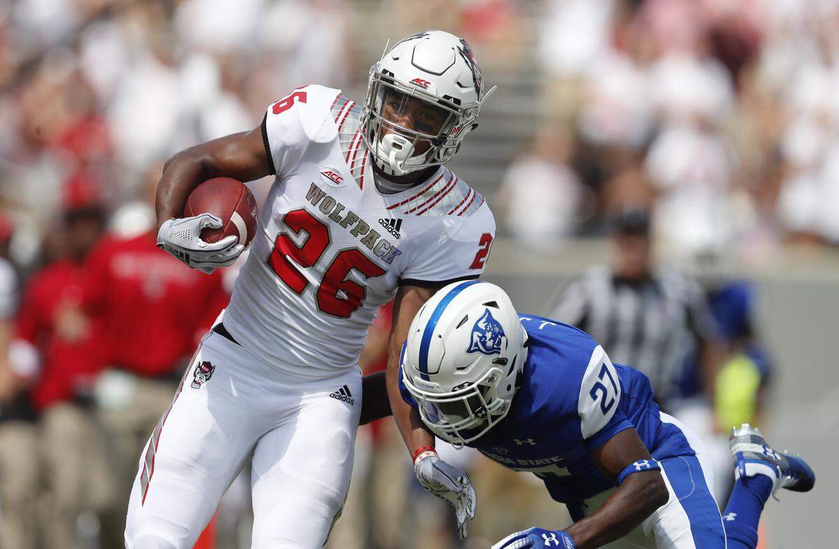 N.C. State’s Trent Pennix (26) tries to avoid the tackle by Georgia State safety Jaylon Jones (27) on a 56-yard pass reception during the Wolfpack’s victory at Carter-Finley Stadium Saturday, Sept. 8, 2018.