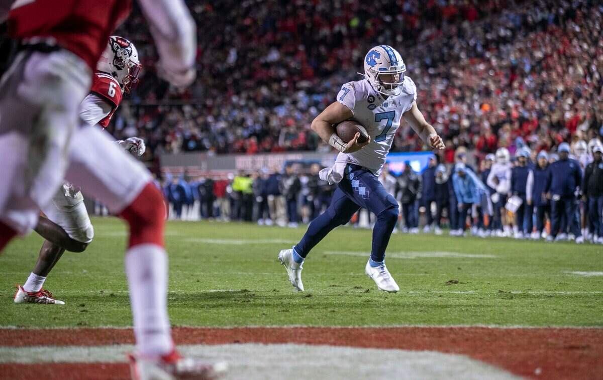 North Carolina quarterback Sam Howell (7) scores on a four yard run in the second quarter against N.C. State on Friday, November 26, 2021 at Carter-Finley Stadium in Raleigh, N.C.