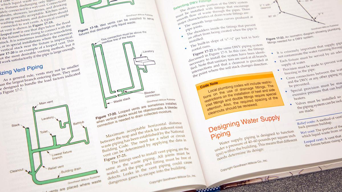 A plumbing textbook sits open on a desk during a plumbing class taught by Robert Brewer at Durham Technical Community College on Thursday, Aug. 30, 2019, in Durham, NC.