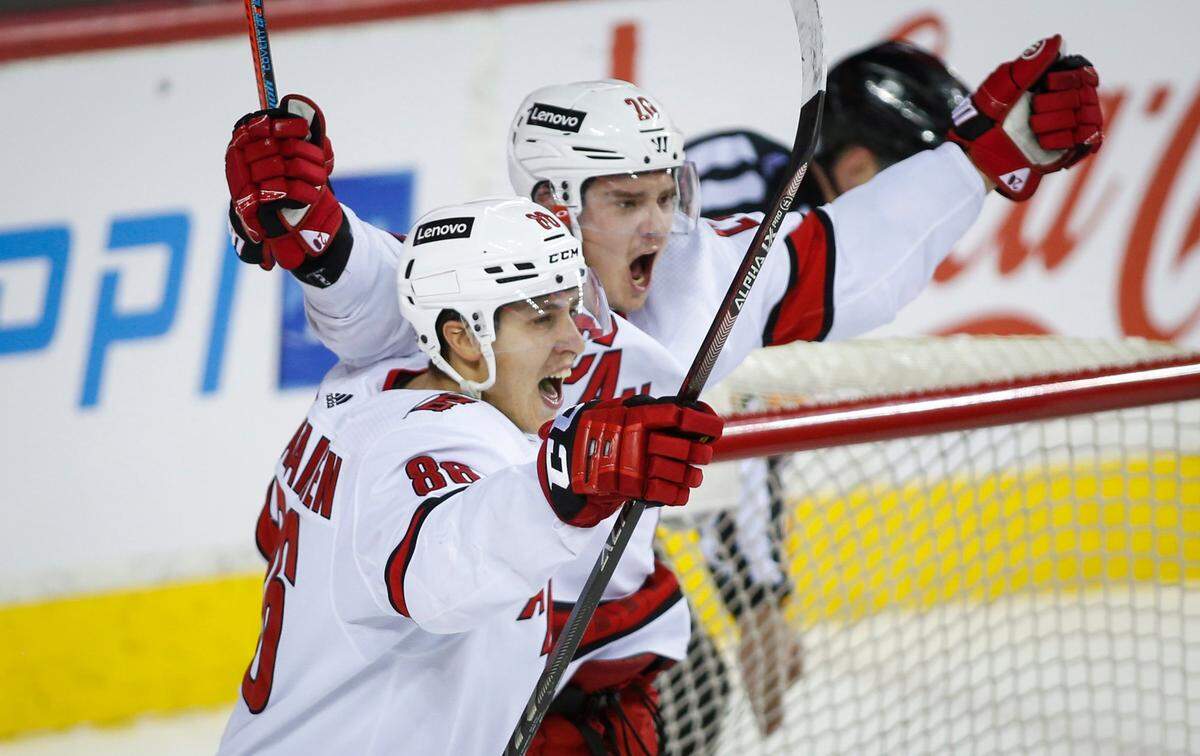 Carolina Hurricanes’ Sebastian Aho, right, celebrates his overtime goal against the Calgary Flames with Teuvo Teravainen in an NHL hockey game Thursday, Dec. 9, 2021, in Calgary, Alberta. (Jeff McIntosh/The Canadian Press via AP)