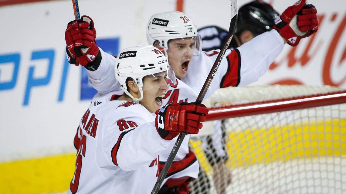 Carolina Hurricanes’ Sebastian Aho, right, celebrates his overtime goal against the Calgary Flames with Teuvo Teravainen in an NHL hockey game Thursday, Dec. 9, 2021, in Calgary, Alberta. (Jeff McIntosh/The Canadian Press via AP)