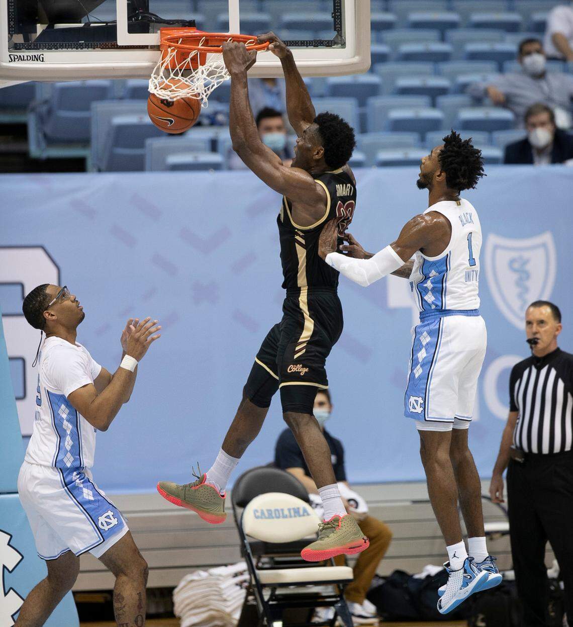 College of Charleston’s Osinachi Smart (33) gets a dunk over North Carolina’s Garrison Brooks (15) during the first half on Wednesday, November 25, 2020 at the Smith Center in Chapel Hill, N.C.
