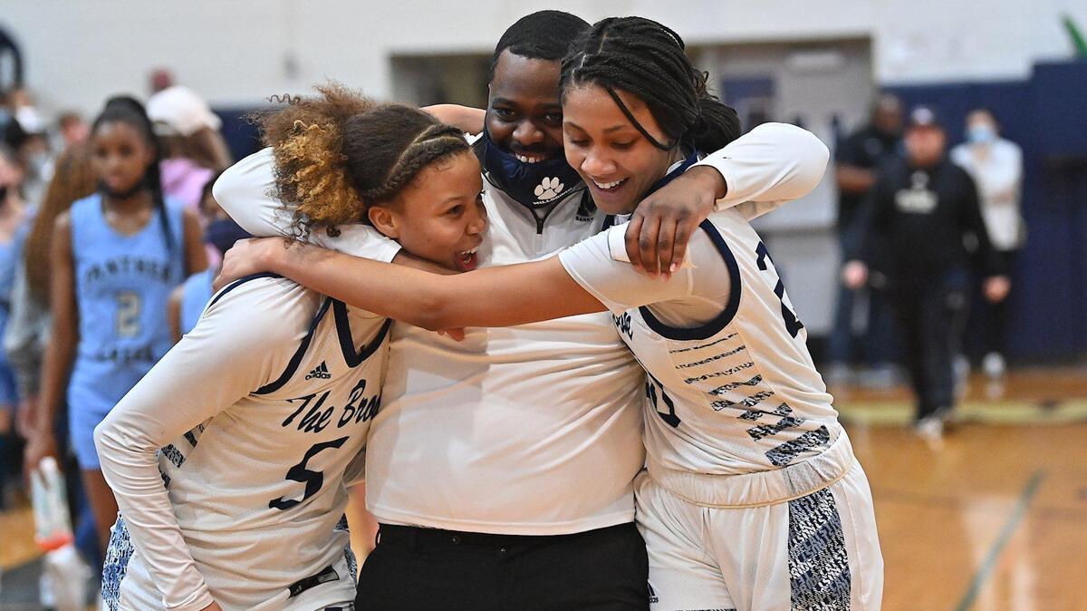 Millbrook Assistant Coach Jeremy Powell celebrates with Reychel Douglas (5) and Corrie McLaughlin (20) after their defeat of Panther Creek. The Millbrook Wildcats and the Panther Creek Catamounts met in a NCHSAA 4A fourth round game in Raleigh, N.C. on March 1, 2022.