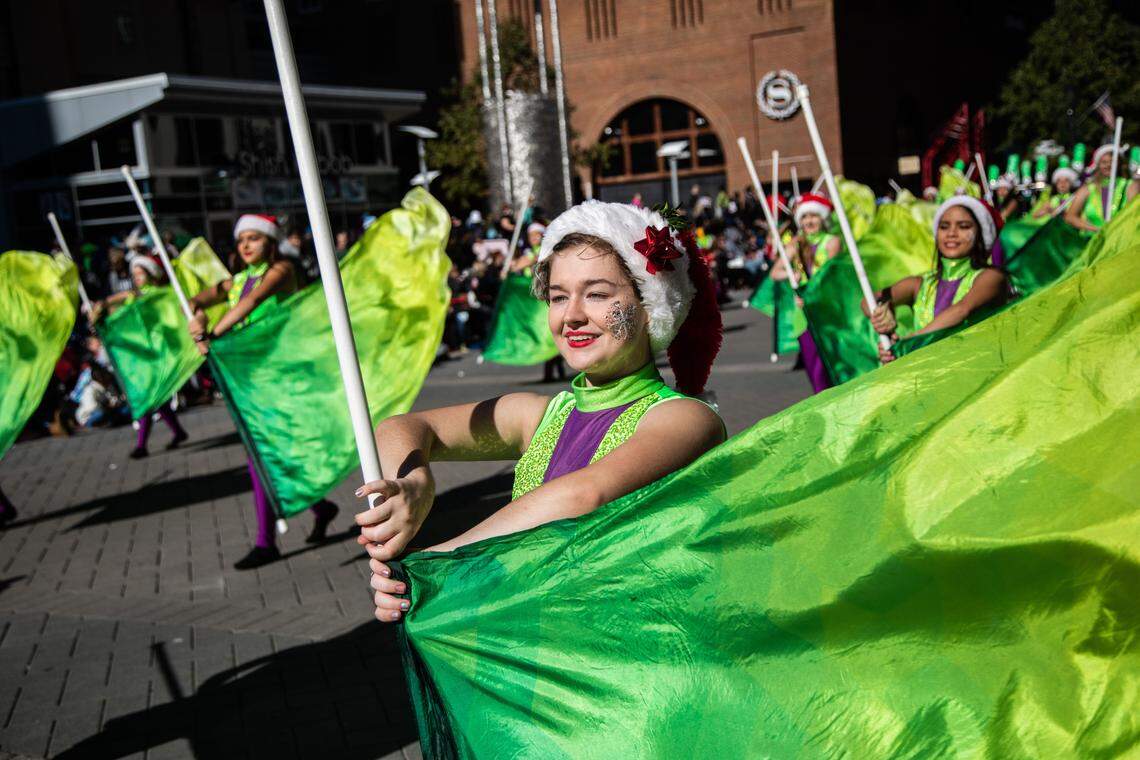 Flag twirlers march with the Cary High marching band during Raleigh’s annual Christmas parade Saturday, Nov. 17, 2018 on Fayetteville Street in downtown Raleigh. Tens of thousands of spectators lined the 1.4-mile route with a curbside view of traditional marching bands, floats and costumed characters, mixed with a sampling of entries entirely unique to Raleigh.