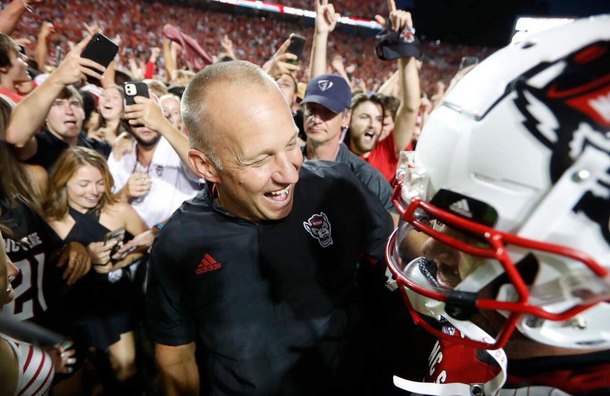 N.C. State head coach Dave Doeren celebrates with quarterback Devin Leary after of N.C. State’s 27-21 overtime victory over Clemson at Carter-Finley Stadium in Raleigh, N.C., Saturday, Sept. 25, 2021.