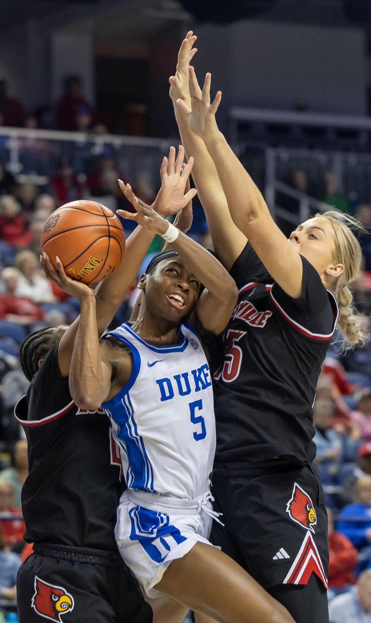 Duke’s Oluchi Okananwa (05) drives to the basket between Louisville’s Mackenly Randolph (4) and Isla Juffermans (15) during the first half on Friday, March 7, 2024 during the quarterfinals of the ACC Women’s Tournament in Greensboro, N.C.
