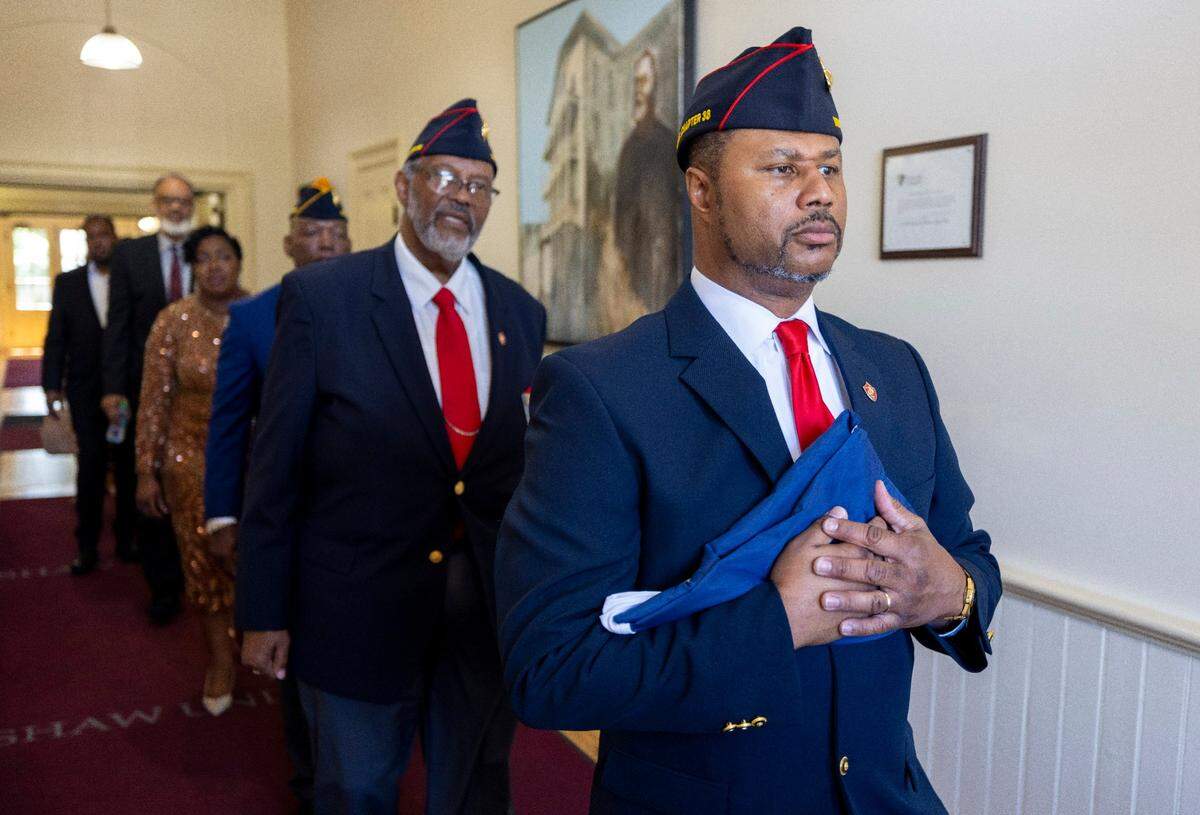 Ritchie Smith, a member of the Montford Point Marines honor guard, carries the Juneteenth Flag from Estey Hall during a ceremony at Shaw University on Thursday, June 19, 202 in Raleigh, N.C.
