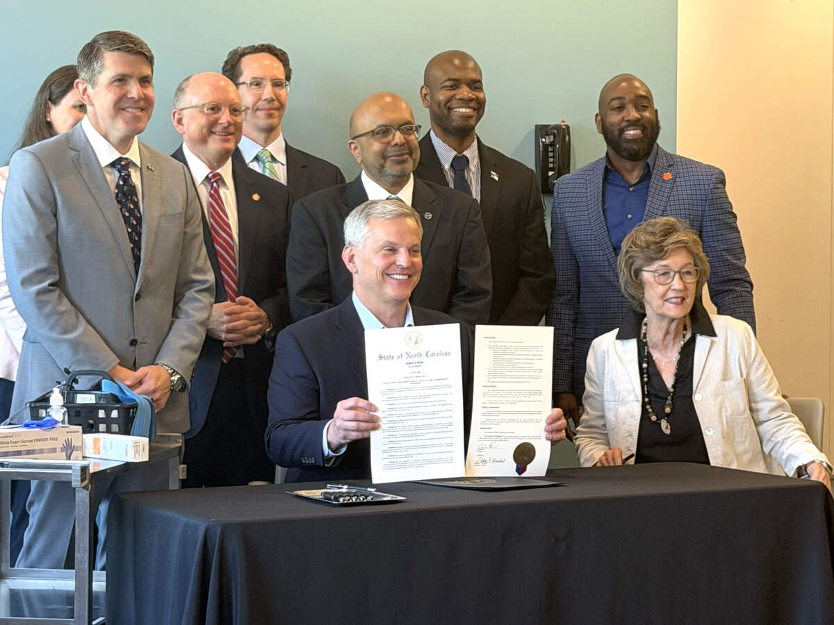 Gov. Josh Stein shows the signed executive order creating a new bipartisan advisory board to examine rising healthcare costs.
