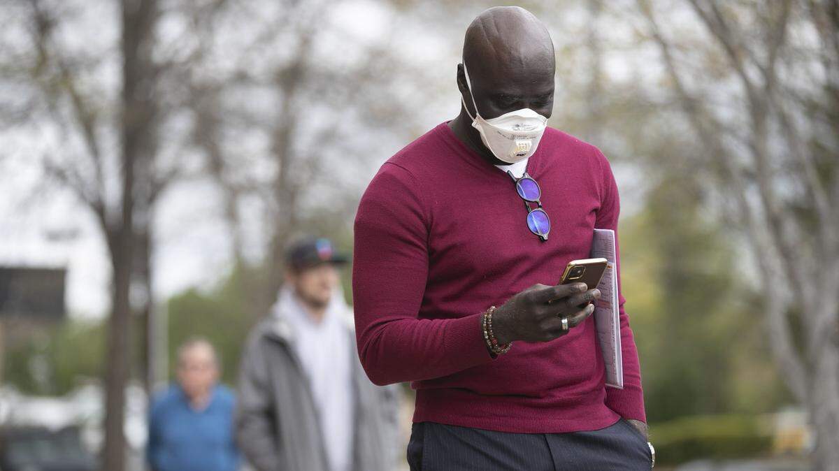 Eric Smith of Durham practices social distancing as he waits in line to enter the state Department of Motor Vehicles office on Maynard Road in Cary, on April 1.