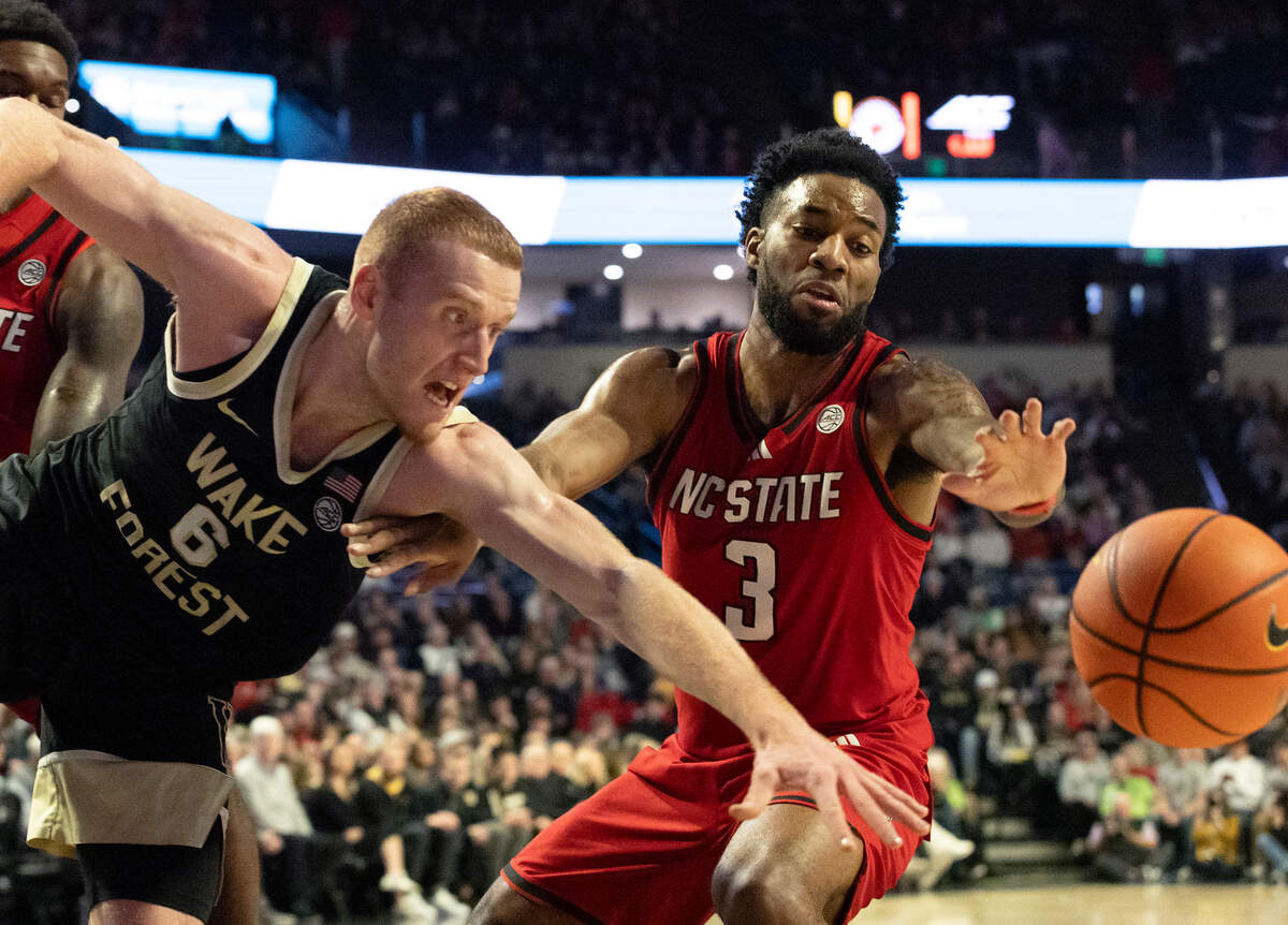 Wake Forest’s Cameron Hildreth and N.C. State’s Dontrez Styles lunge after a loose ball during the first half of the Wolfpack’s 77-59 loss on Saturday, Jan. 4, 2025, at Lawrence Joel Veterans Memorial Coliseum in Winston-Salem, N.C.