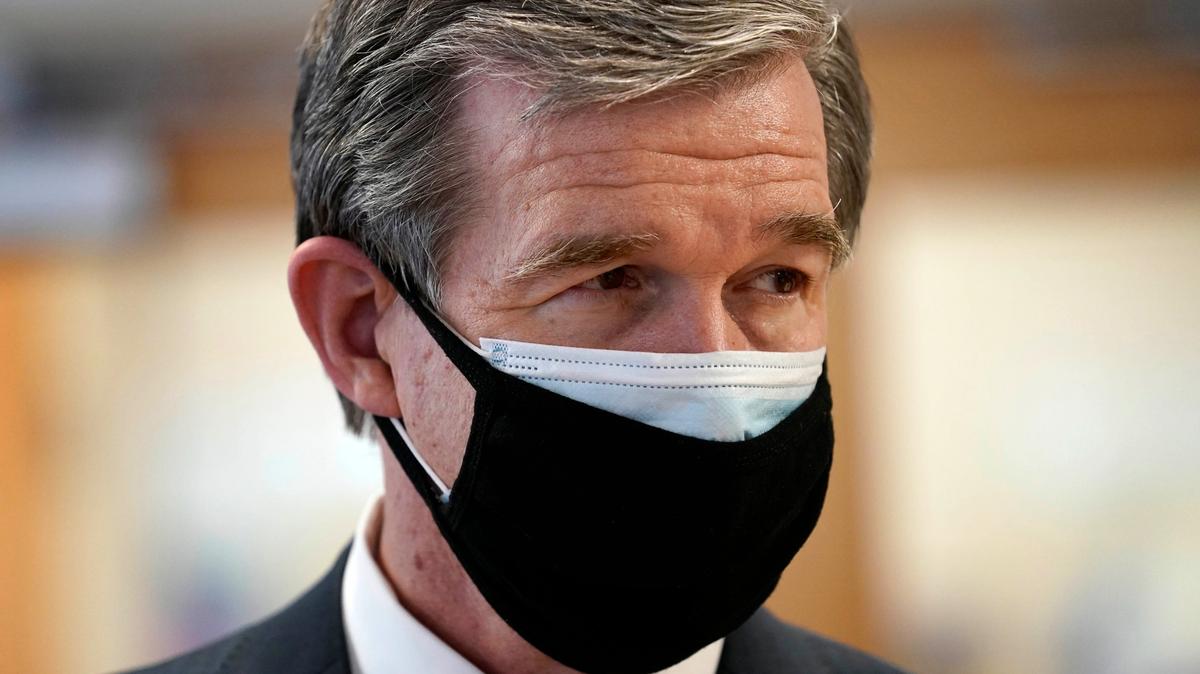 Gov. Roy Cooper, wearing two masks, tours Piedmont Health Senior Care, a federally qualified health center where PACE patients (Program of All-Inclusive Care for the Elderly) and underserved populations can receive the COVID-19 vaccine Thursday, Jan. 28, 2021 in Pittsboro, N.C.