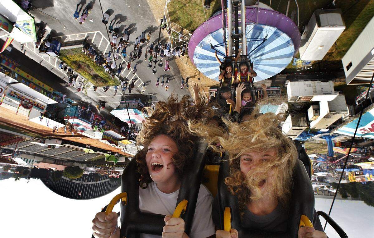 Courtney Stegall,12, left and pal Scarlett Harris,13 ride the Ring of Fire at the North Carolina State Fair Thursday Oct.18, 2007. The girls were visiting the fair from Cornerstone Christian School in Roanoke Rapids. Morning showers made way for a hot steamy afternoon the sixth day of the fair.