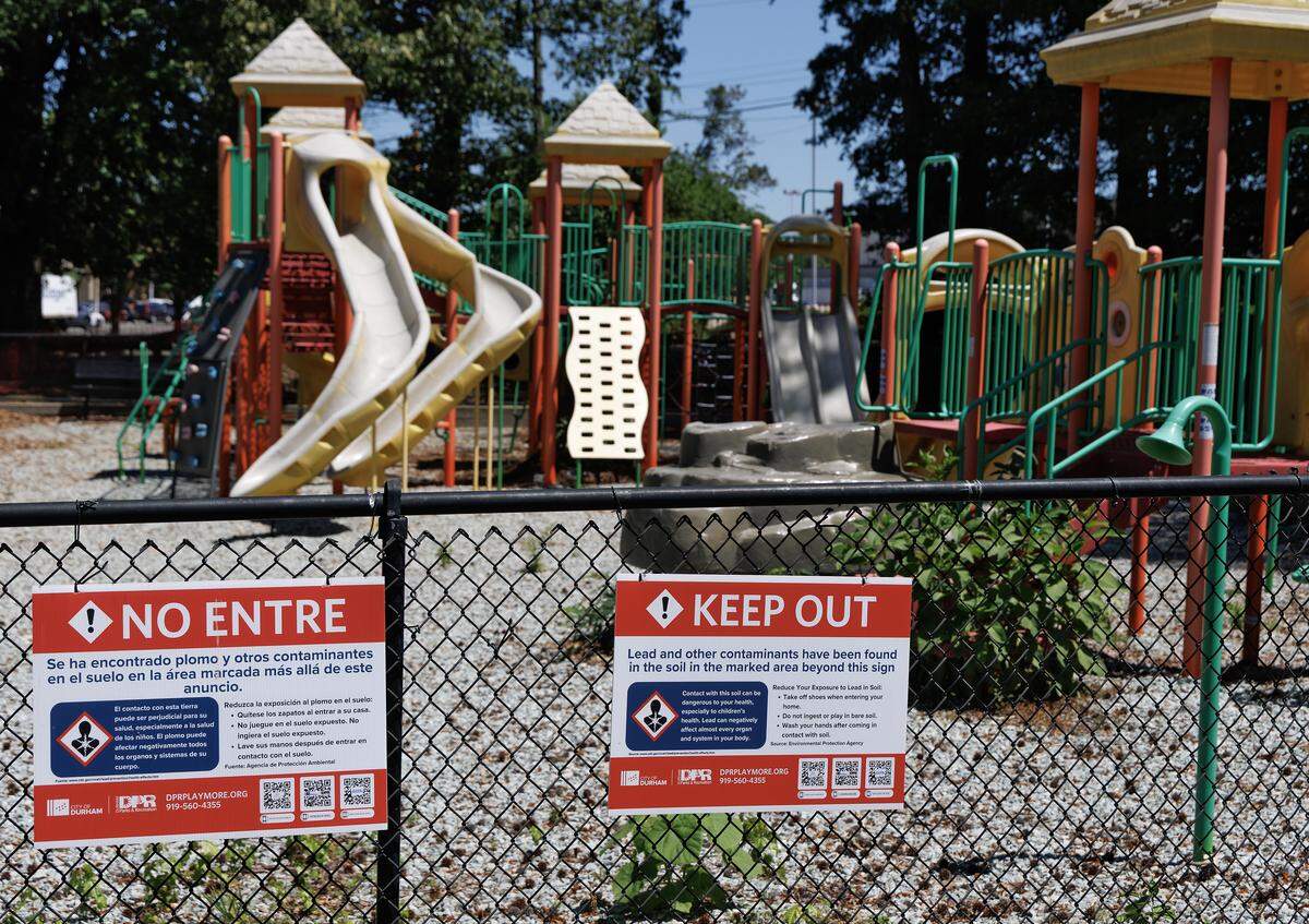 Signs warn of lead found in the soil near a playground area at Walltown Park on Friday, May 8, 2026, in Durham, N.C. The park is one of five in the city that remains closed after the sites were found to have high levels of lead in the soil. 