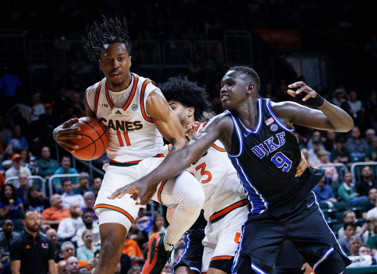 Miami (Fl) Hurricanes guard A.J. Staton-McCray (11) grabs a rebound over Duke Blue Devils center Khaman Maluach (9) during the first half of a game on Tuesday, Feb. 25, 2025, at Watsco Center in Coral Gables, Fla.