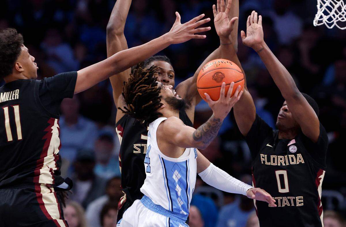 North Carolina’s RJ Davis (4) shoots while defended by Florida State’s Baba Miller (11), Jaylan Gainey (33) and Chandler Jackson (0) during second half of UNC’s 92-67 victory over Florida State in the quarterfinal round of the 2024 ACC Men’s Basketball Tournament at Capital One Arena in Washington, D.C., Thursday, March 14, 2024.