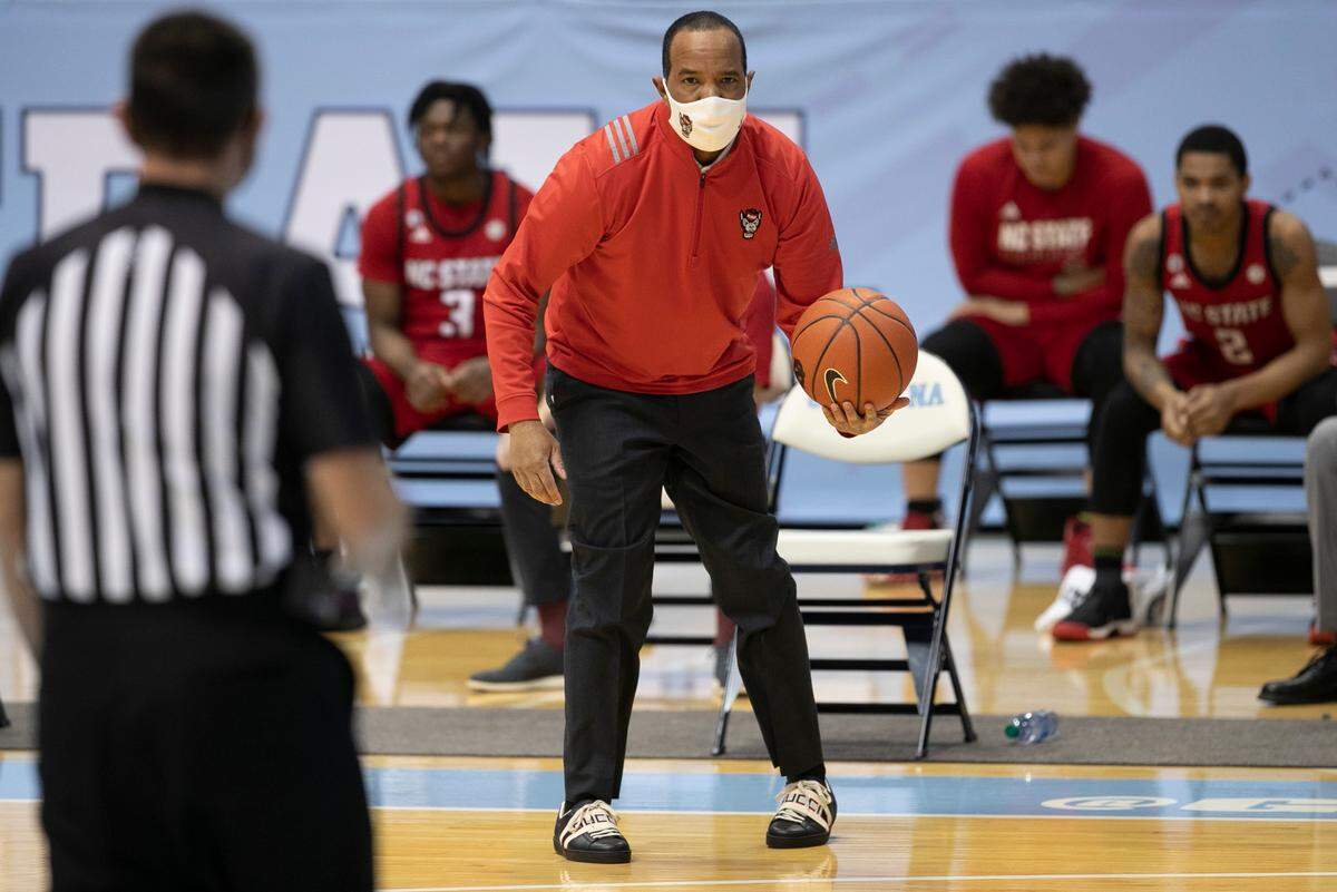N.C. State coach Kevin Keatts returns the ball to the official during the first half against North Carolina on Saturday, January 23, 2021 at the Smith Center in Chapel Hill, NC.