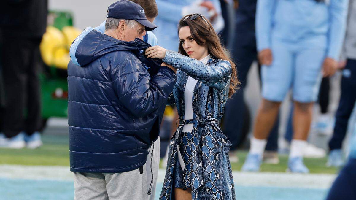 Jordon Hudson, girlfriend of UNC football coach Bill Belichick, adjusts his coat during UNC football’s Practice Like a Pro open practice at Kenan Stadium in Chapel Hill, N.C., Saturday, April 12, 2025.