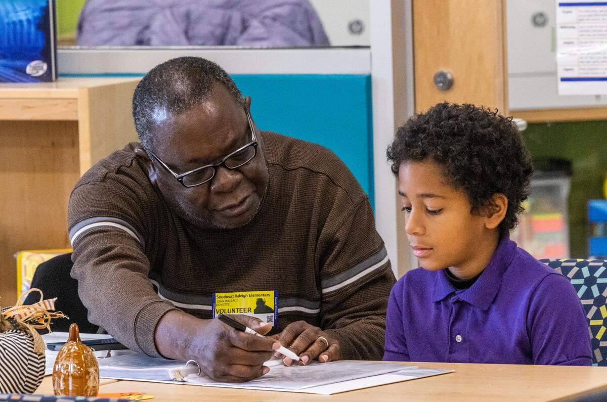 Volunteer tutor John Boyette and Wesley Volkel, 9, take part in the new WakeTogether tutoring program designed to help Wake County elementary students recover from pandemic learning loss Thursday, Nov. 17, 2022 at Southeast Raleigh Elementary School.
