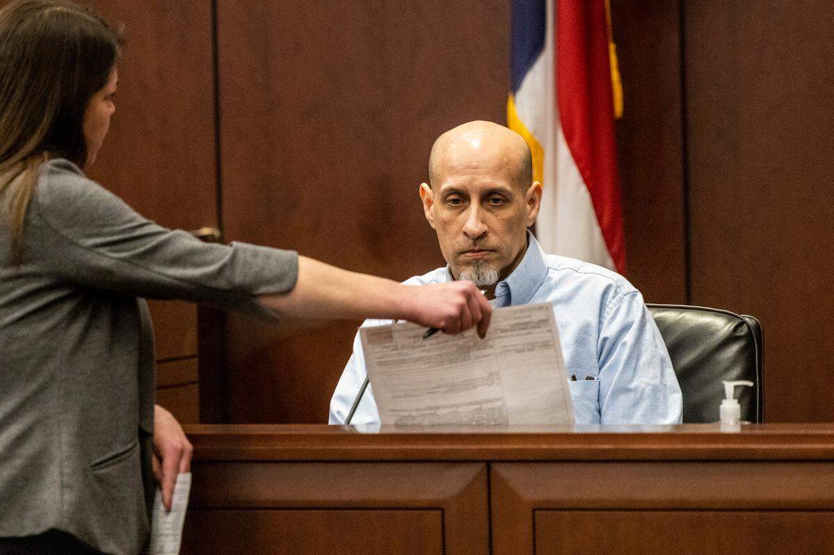 Prosecuter Kathryn Pomeroy presents Brian Sluss with evidence as he testifies in his own defense Wednesday, April 27, 2022 in Wake county District Court. Sluss, 46, is charged with the murder of Monica Moynan, who was 23 when she was last seen in Holly Springs in April 2019. Moynan, who shared two children with Sluss, was reported missing in mid-July of 2019, and her body has never been found.