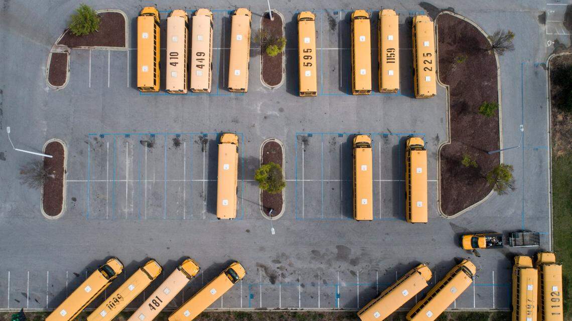 School buses sit in their designated parking lot on the empty campus of Green Hope High School in Cary, N.C. Thursday, March 26, 2020.