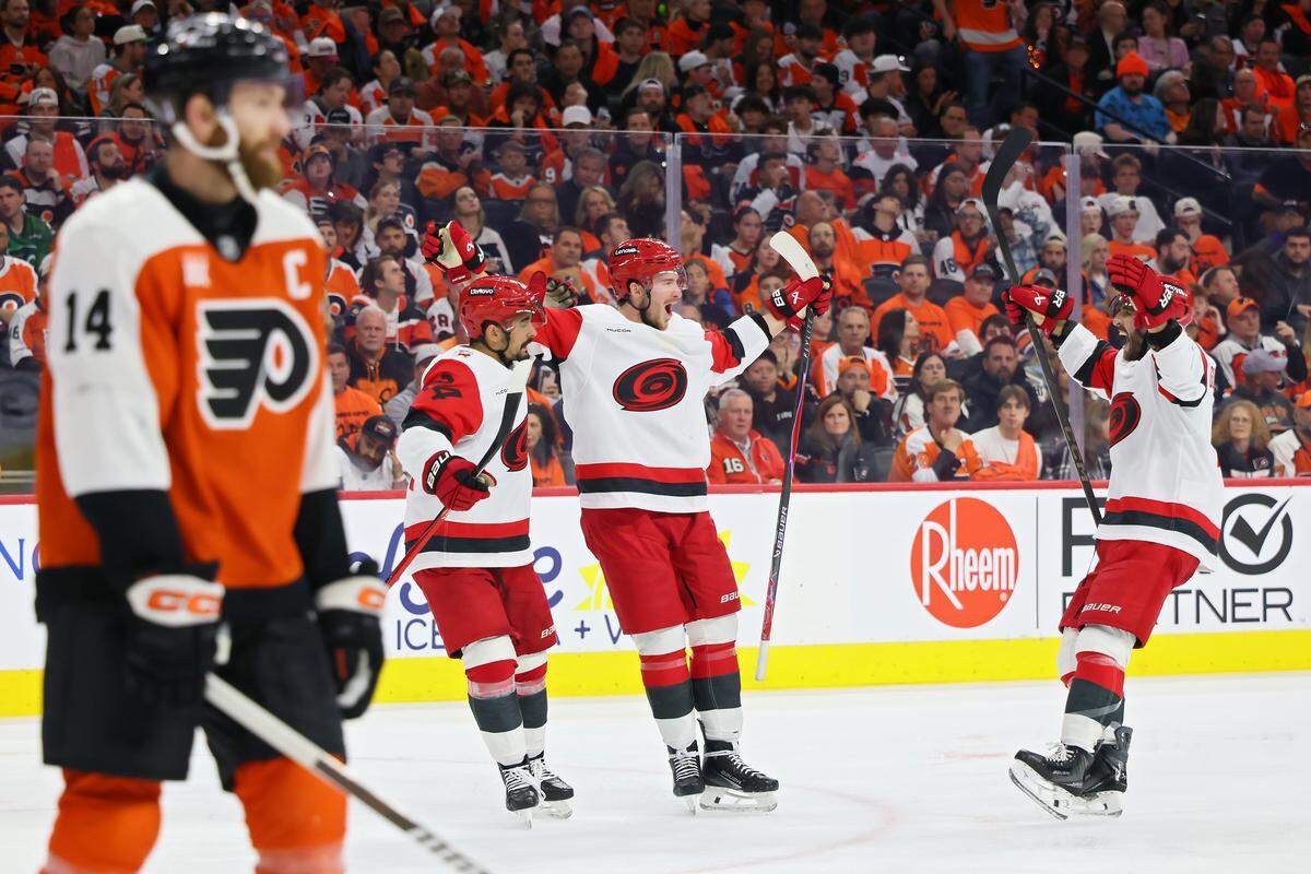 Andrei Svechnikov (center) of the Carolina Hurricanes celebrates a goal with teammates Seth Jarvis and Shayne Gostisbehere during the third period of Game 3 of their second-round Stanley Cup Playoff series at Xfinity Mobile Arena on May 7, 2026 in Philadelphia, Pennsylvania.