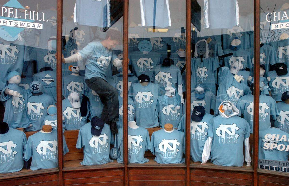 Chapel Hill Sportswear employee Anne Frautschi helps decorate a window display Feb. 4, 2004 at the store on Franklin St. in Chapel Hill. Profits from the “turn it blue” T-shirts will benefit charity.