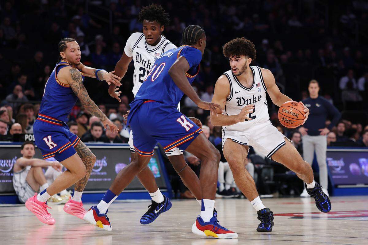 Cameron Boozer (12) of the Duke Blue Devils dribbles against Flory Bidunga (40) of the Kansas Jayhawks during the first half in the 2025 State Farm Champions Classic at Madison Square Garden on November 18, 2025 in New York City.  