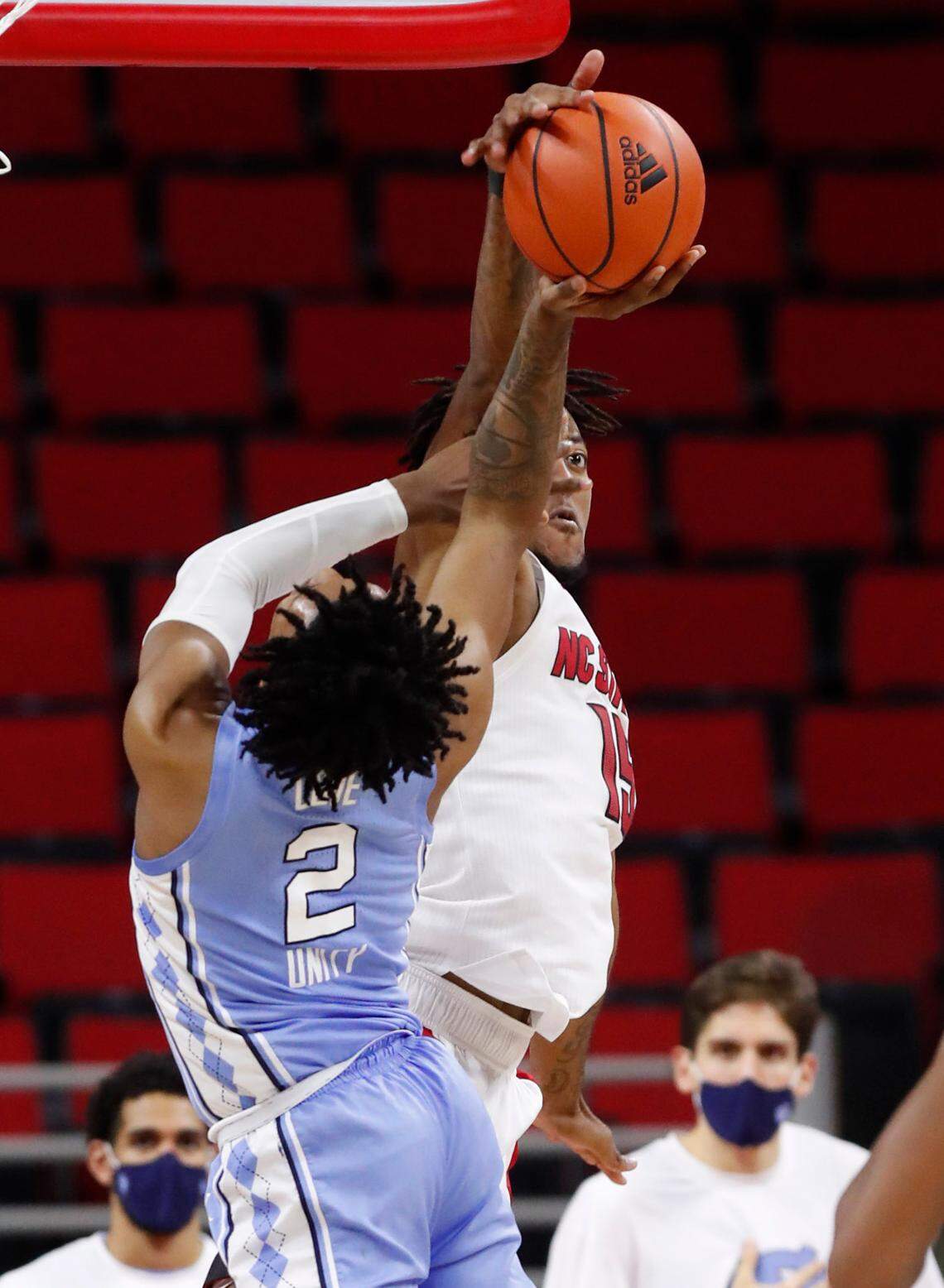 N.C. State’s Manny Bates (15) blocks the shot by North Carolina’s Caleb Love (2) during the second half of N.C. State’s 79-76 victory over UNC at PNC Arena in Raleigh, N.C., Tuesday, December 22, 2020.