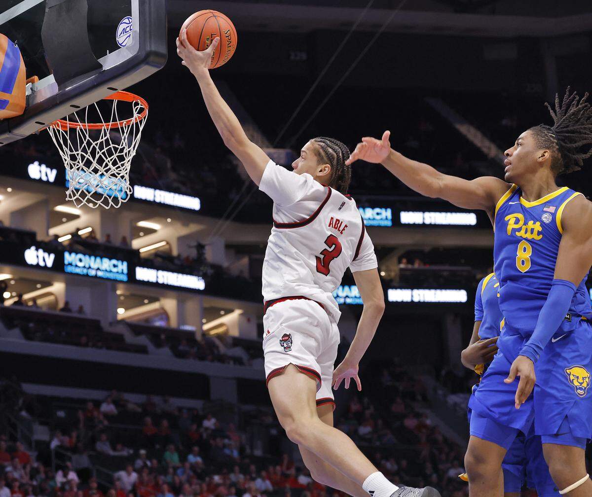 N.C. State's Matt Able drives to the basket past Pitt’s Omari Witherspoon during the second half of the Wolfpack’s 98-88 win in the second round of the ACC Tournament on Wednesday, March 11, 2026, at the Spectrum Center in Charlotte, N.C.