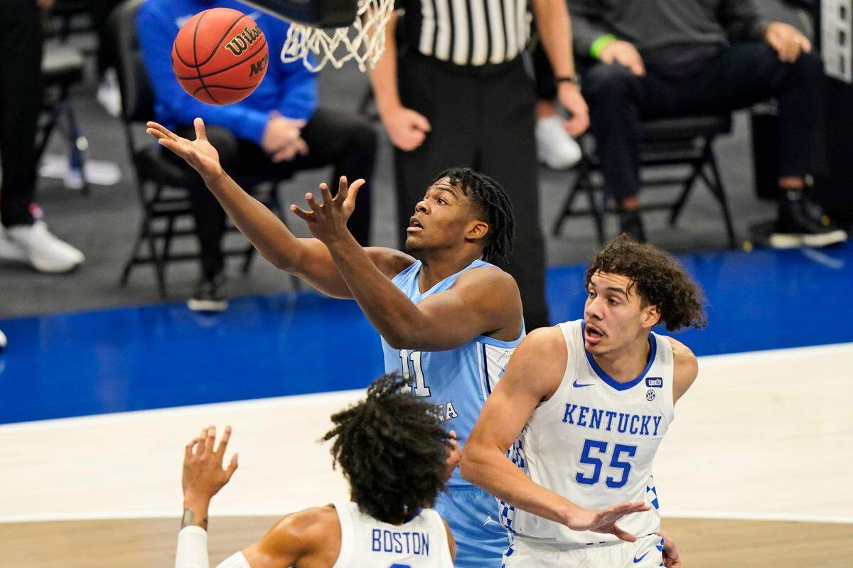 North Carolina’s Day’Ron Sharpe (11) tries to get a rebound ahead of Kentucky’s Lance Ware (55) and Brandon Boston Jr. (3) in the first half of an NCAA college basketball game, Saturday, Dec. 19, 2020, in Cleveland.