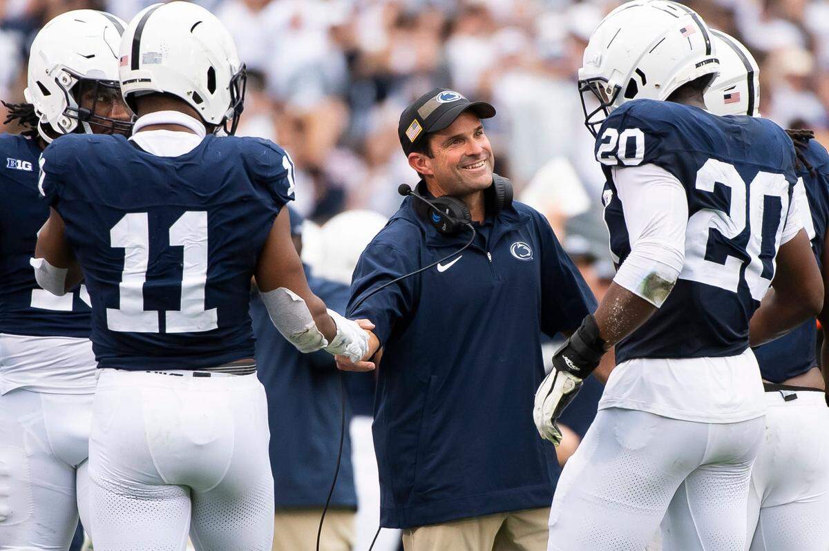 Penn State defensive coordinator Manny Diaz grins as his unit comes to the sideline after creating a turnover late in the the second half of their game against Indiana at Beaver Stadium Oct. 28, 2023, in State College, Pa.