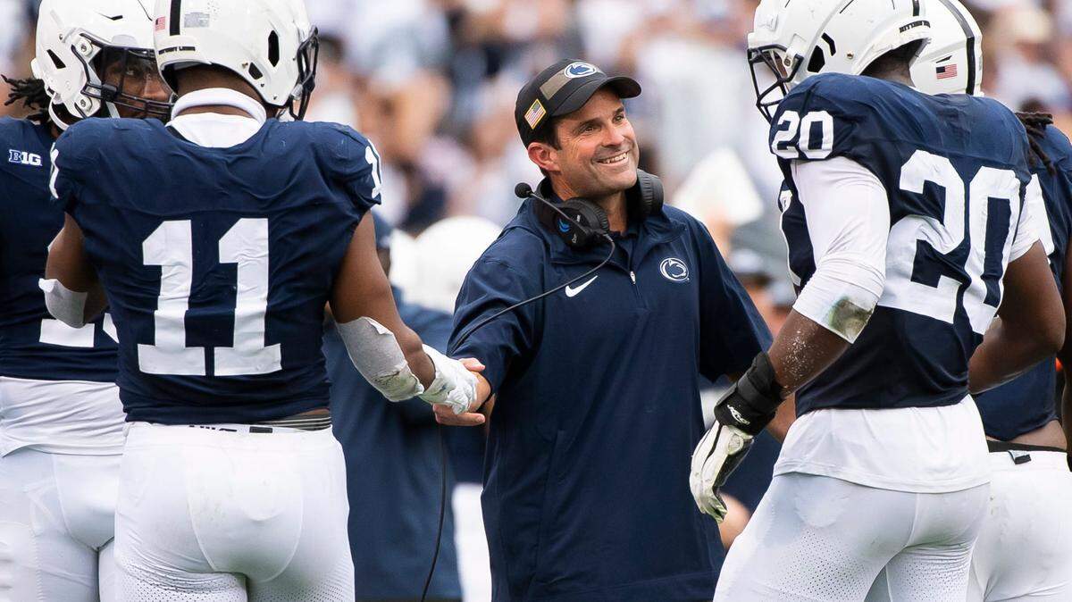 Penn State defensive coordinator Manny Diaz grins as his unit comes to the sideline after creating a turnover late in the the second half of their game against Indiana at Beaver Stadium Oct. 28, 2023, in State College, Pa.