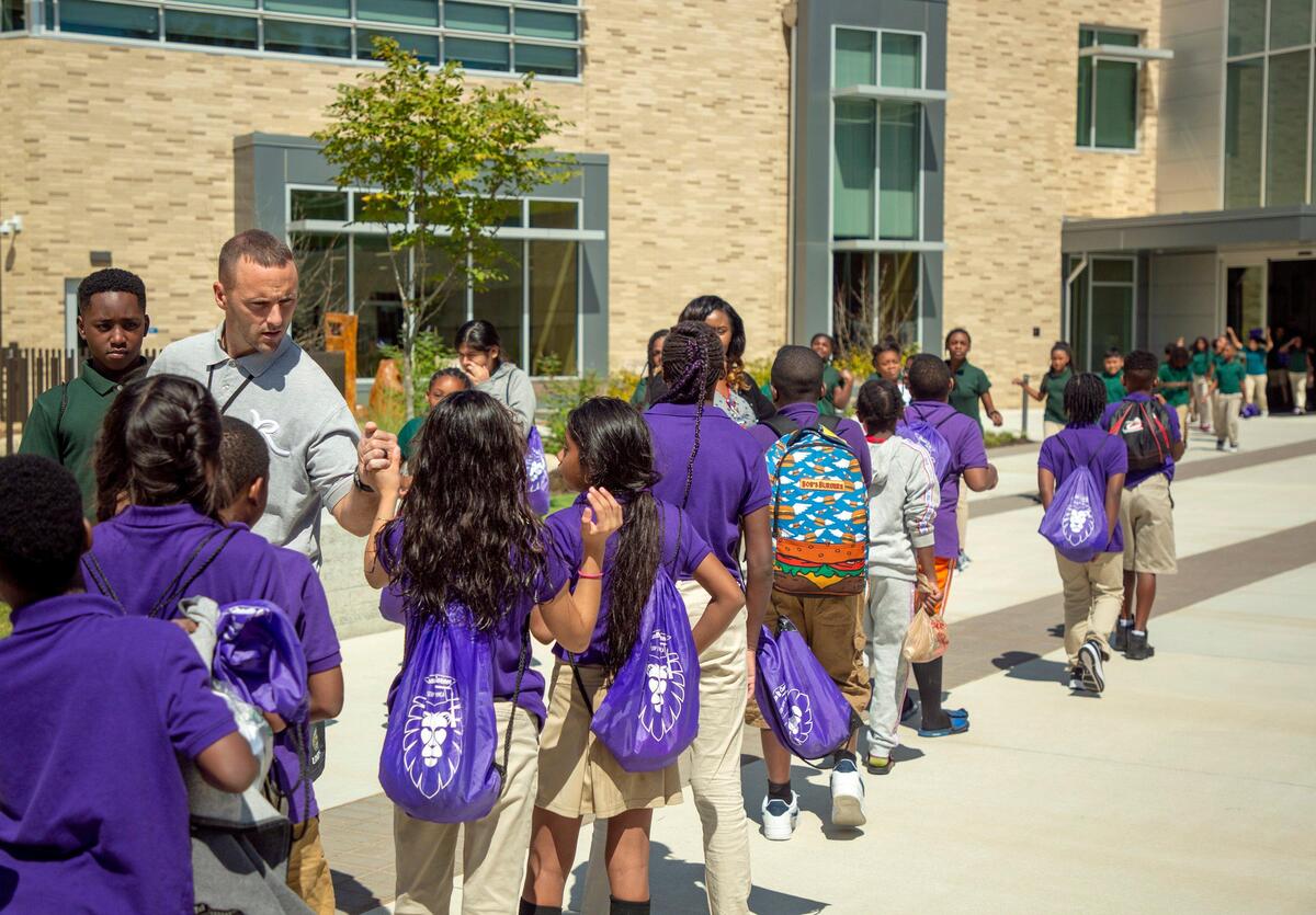 P.E. teacher Dave Jones sends off a class of 4th graders after completing their swim lesson with YMCA swim instructors at Southeast Raleigh Elementary School on Wednesday, Sep. 18, 2019, in Raleigh, NC. The school opened in August and features a wide range of partnerships, including the YMCA facilities.