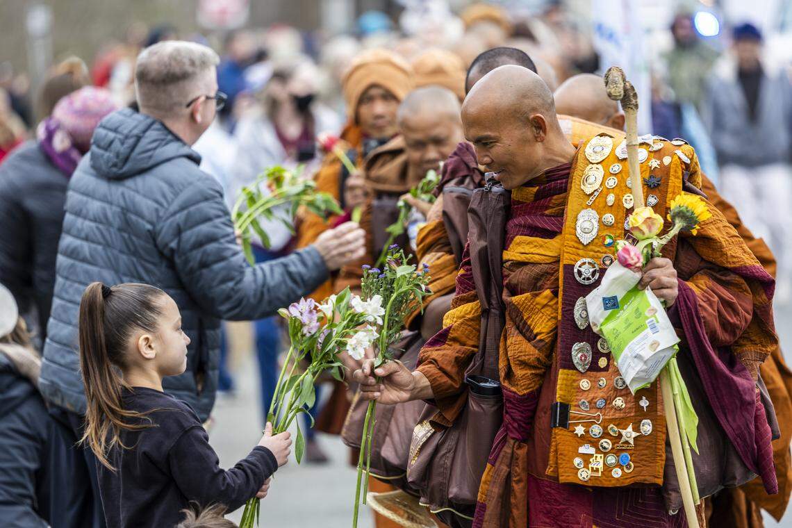 A small procession of Buddhist monks walks along U.S. Highway 64 west of Pittsboro on Thursday, Jan. 22, 2026, as hundreds of onlookers line the highway to welcome them. The monks are making a 2,300-mile pilgrimage from Texas to Washington, D.C., as part of the “Walk for Peace,” an effort to promote peace, compassion and national unity.