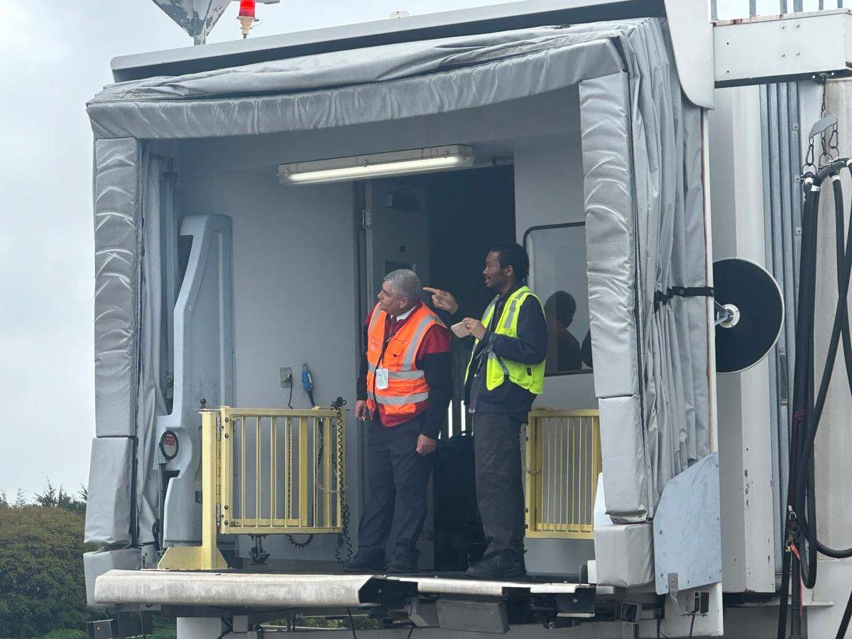 Workers at Raleigh-Durham International Airport watch the arrival of BermudAir’s inaugural flight to the Triangle from the jet bridge where passengers will get off the plane. The flight arrived Friday morning, April 11, 2025.