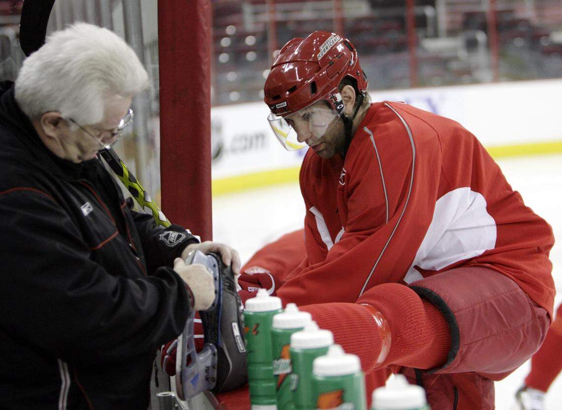 Former Carolina Hurricanes equipment manager Wally Tatomir checks Erik Cole’s skate during a 2006 practice.